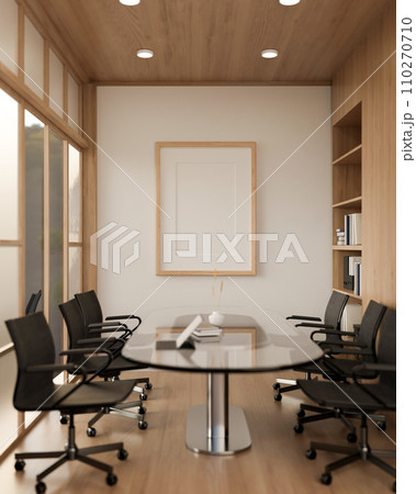 A minimal wood picture frame mockup on a white wall in a modern meeting room. 110270710