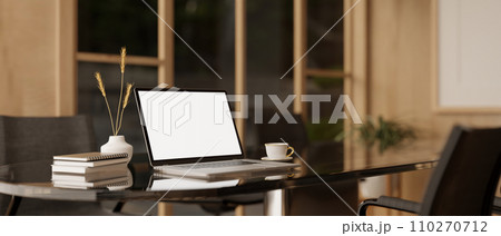 A white-screen laptop computer mockup and accessories on a meeting table in a modern meeting room. 110270712