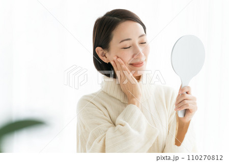 鏡を持ち肌のチェックをする女性 110270812