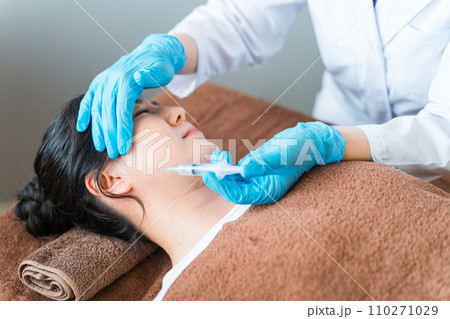 エラ・咬筋縮小・顔にヒアルロン酸・ボトックス・脂肪溶解注射を打つ患者と美容外科の医師 エラ・咬筋縮小・顔にヒアルロン酸・ボトックス・脂肪溶解注射を打つ患者と美容外科の医師 110271029