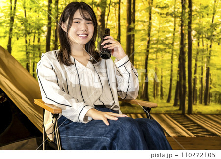 グランピング キャンプでビールを片手に微笑む若い女性 グランピング キャンプでビールを片手に微笑む若い女性 110272105
