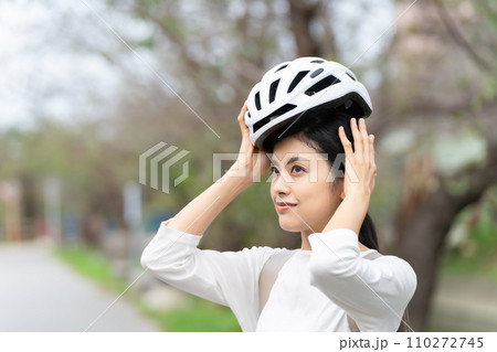 白いサイクリングヘルメットを被る若い女性 110272745