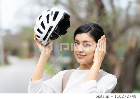 白いサイクリングヘルメットを被る若い女性 110272749