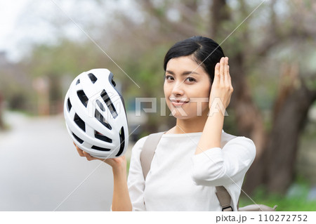 白いサイクリングヘルメットを被る若い女性 110272752