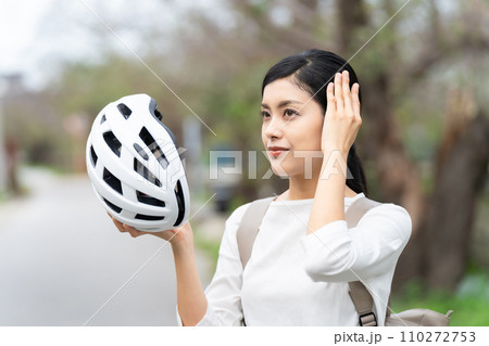 白いサイクリングヘルメットを被る若い女性 110272753