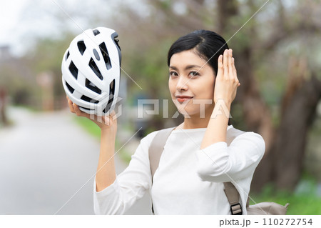 白いサイクリングヘルメットを被る若い女性 110272754