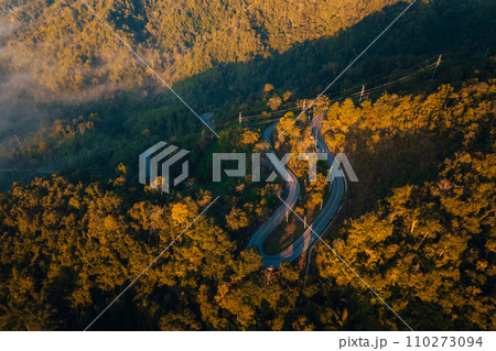 Aerial view of road in mountain valley at sunrise Aerial view of road in mountain valley at sunrise 110273094