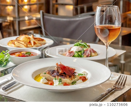 レストランのテーブルに並んだ料理とワイン　イタリアン	AI画像 110273606