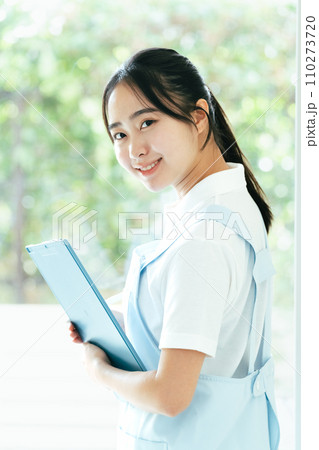 窓際に立つ介護士の若い女性 窓際に立つ介護士の若い女性 110273720