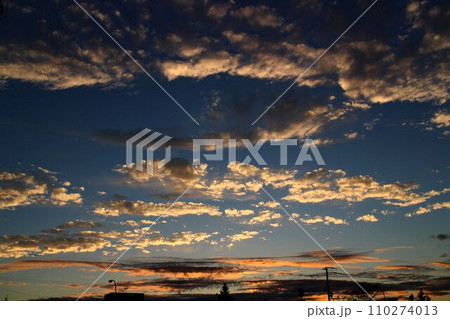 夕焼で赤く染まる黒雲 110274013