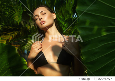 beautiful summer girl in sunset. young sexy woman in bikini under palm tree 110274757