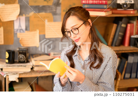 椅子に座って本を読む女性 110275031