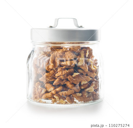 Peeled dried walnut kernels in jar isolated on white background. Peeled dried walnut kernels in jar isolated on white background. 110275274