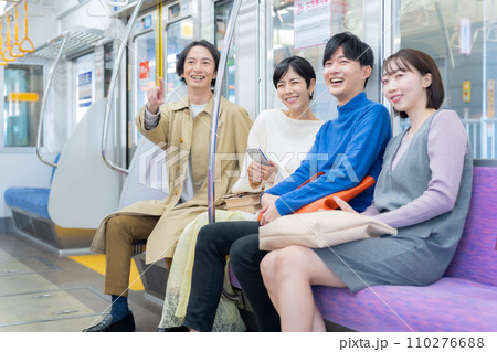 スマホを見ながら電車に乗る若い女性と友達　撮影協力「京王電鉄株式会社」 110276688