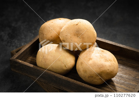 fresh potatoes on a black stone background 110277620