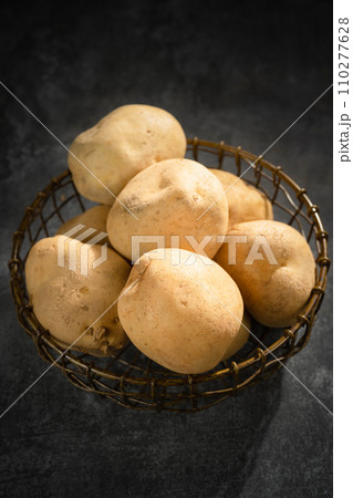 fresh potatoes on a black stone background 110277628