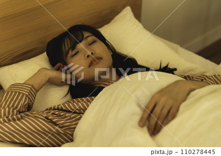 ベッドで熟睡する女性 110278445