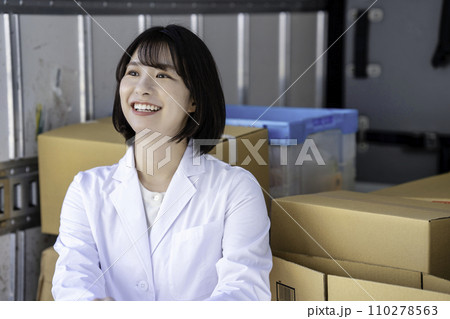 トラックの荷物を検品する白衣の女性 110278563