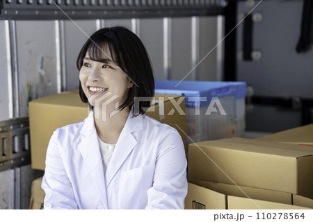 トラックの荷物を検品する白衣の女性 トラックの荷物を検品する白衣の女性 110278564