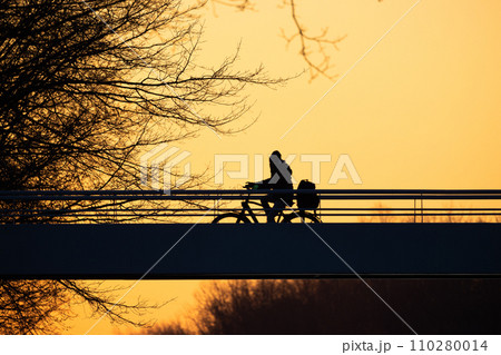 Sunset Ride: Cyclist's Silhouette Against Twilight 110280014