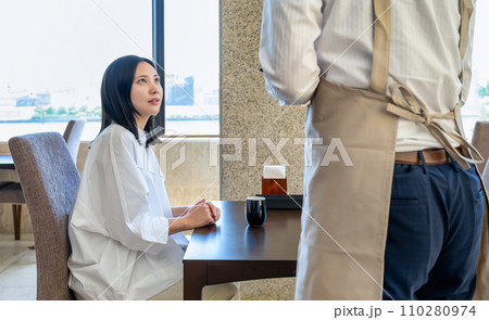 レストラン 若い女性客と注文を取る男性店員 レストラン 若い女性客と注文を取る男性店員 110280974