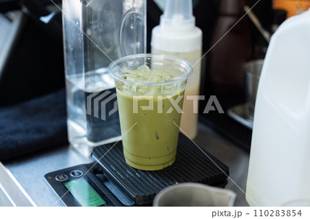 Iced green tea with ice cube in plastic glass Iced green tea with ice cube in plastic glass 110283854