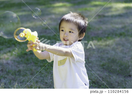 公園でシャボン玉で遊ぶ男の子 110284156