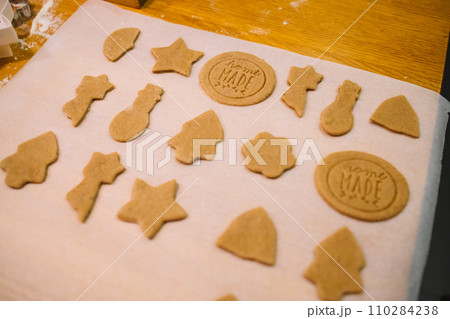 Process of making heart-shaped gingerbread for Christmas and New Year. Traditional festive food making, family culinary. Process of making heart-shaped gingerbread for Christmas and New Year. Traditional festive food making, family culinary. 110284238