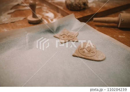 Process of making heart-shaped gingerbread for Christmas and New Year. Traditional festive food making, family culinary. Process of making heart-shaped gingerbread for Christmas and New Year. Traditional festive food making, family culinary. 110284239