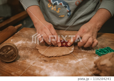 Christmas and New Year celebration traditions. Making cookies of gingerbread dough Christmas and New Year celebration traditions. Making cookies of gingerbread dough 110284241
