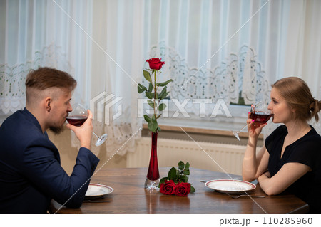 People drink red wine at the table after a family dinner. 110285960