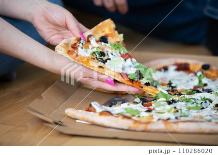 Close-up of a pizza with salami, olives, cheese and sauce. 110286020