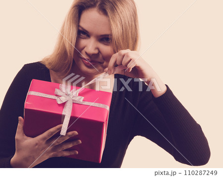 Girl opening pink gift box Girl opening pink gift box 110287249