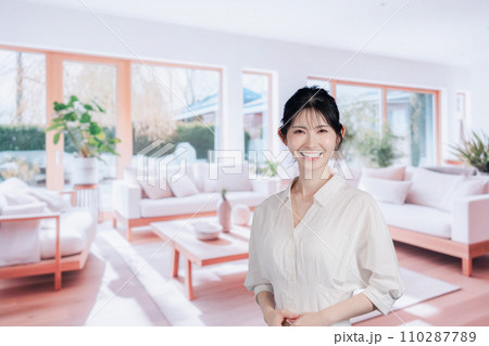明るいリビングで過ごす若い女性 110287789