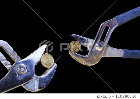 Allegory of the global financial crisis - Iron 10 rubles coin (written ten rubles, Bank of Russia in the Russian) in the grip of economic crisis, on a black background. Finance and business concept 110290510