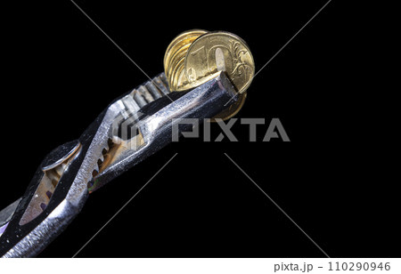 Allegory of the global financial crisis - Iron 10 rubles coin (written ten rubles, Bank of Russia in the Russian) in the grip of economic crisis, on a black background. Finance and business concept 110290946