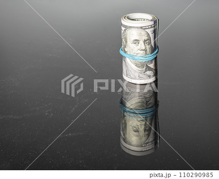 One hundred dollar bills, on a black background 110290985