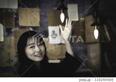 レトロな照明に手をかざす女性 レトロな照明に手をかざす女性 110293569