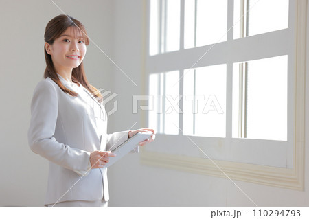 窓の近くでタブレットを持つビジネスウーマン1 110294793