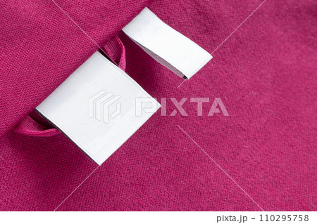 Blank white laundry care clothes label on red fabric texture background 110295758