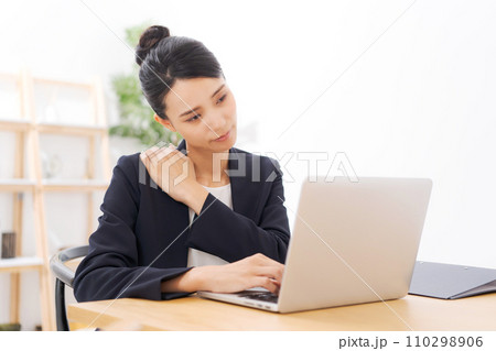 肩こりに悩むスーツの20代女性 肩こりに悩むスーツの20代女性 110298906