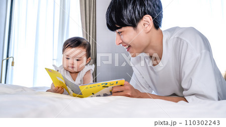 娘に絵本を読み聞かせるパパ 娘に絵本を読み聞かせるパパ 110302243