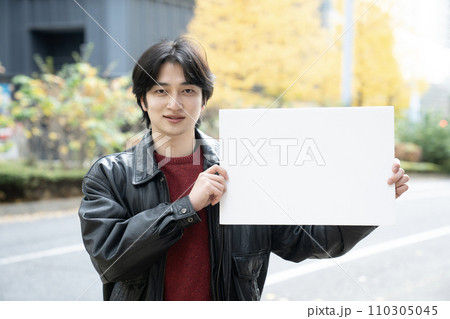 冬の西新宿でホワイトボードを持つ若者 冬の西新宿でホワイトボードを持つ若者 110305045
