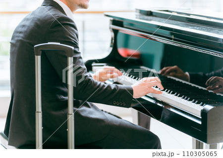 駅でピアノ・フリーピアノ・ストリートピアノを演奏するビジネスマン・ピアニスト 110305065