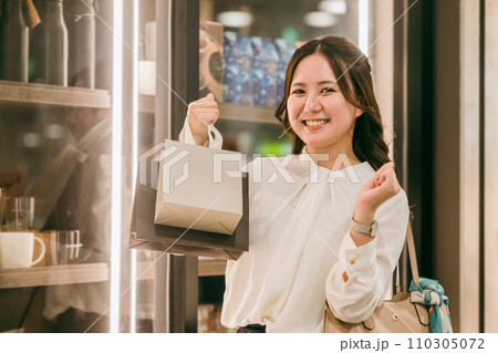 ショーウィンドウの商品を見てショッピングを楽しむビジネスウーマン ショーウィンドウの商品を見てショッピングを楽しむビジネスウーマン 110305072