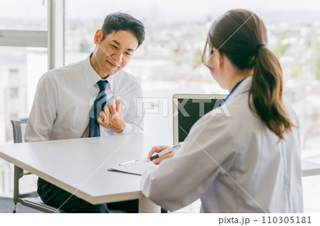 胸の痛みを医師に訴える中年男性(心臓病・不整脈・息切れ・動悸) 胸の痛みを医師に訴える中年男性(心臓病・不整脈・息切れ・動悸) 110305181
