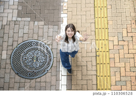 街中を散歩する若い女性 俯瞰撮影 街中を散歩する若い女性 俯瞰撮影 110306528