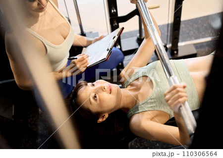 バーベルベンチプレスで胸を鍛える女性 110306564