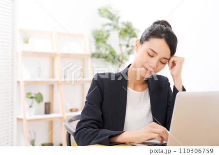 頭を抑えるスーツの20代女性 110306759