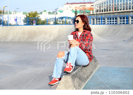 a confident young woman walks through the streets of the city, a woman smiles and enjoys life 110306802
